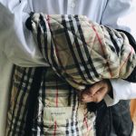 Jesse holding a Burberry coat and wearing a Vivienne Westwood shirt